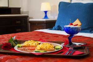 a tray with breakfast foods and a drink on a bed at Vasilaras Hotel in Skala