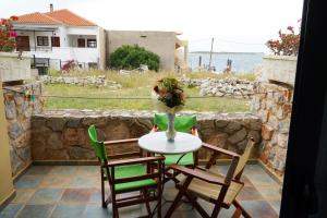a table with chairs and a vase of flowers on a patio at Vasilaras Hotel in Skala