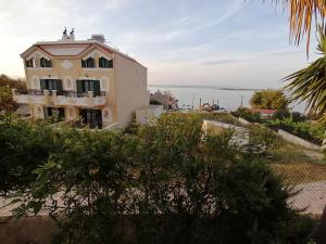 a building on a hill with the ocean in the background at Vasilaras Hotel in Skala