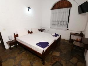 a bedroom with a large white bed with a window at Vasilaras Hotel in Skala