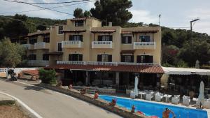 a hotel with a swimming pool in front of a building at Vasilaras Hotel in Skala