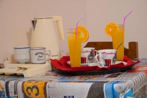 a table with a tray with two orange juice at Vasilaras Hotel in Skala