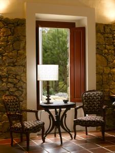 Reguengo GrandeにあるCasal da Serranaの椅子2脚、テーブル、窓が備わる客室です。