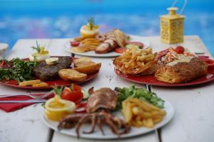 una mesa con cuatro platos de comida. en Vasilaras Hotel, en Skala