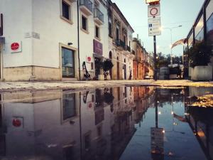 un reflejo de una calle en un charco en una calle de la ciudad en La tana del pescatore, en Brindisi