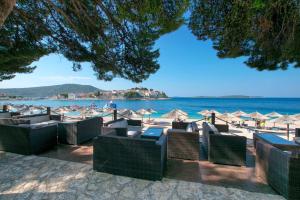 een groep stoelen en parasols op een strand bij Apartment Damir in Primošten