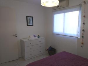a bedroom with a bed and a dresser and a window at Apartamento Benegas in Mendoza