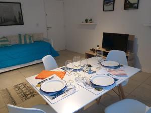 a white table with chairs and plates and wine glasses at Apartamento Benegas in Mendoza