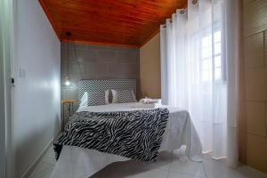 a zebra print bed in a room with a window at Casa Branca in Angra do Heroísmo