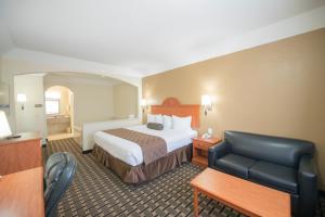 a hotel room with a bed and a chair at Motel 6-Tyler, TX in Tyler +19 photos