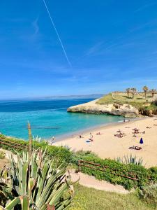 una playa con gente en la arena y el océano en B&B La finestra sul porto, en Porto Torres