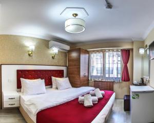 a bedroom with a large bed with a red blanket at Cihangir Palace Hotel in Istanbul