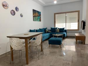 un soggiorno con divano blu e tavolo di suite better than a Hotel jardin de carthage a Tunisi
