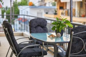 a table and chairs with a potted plant on a balcony at Pearl Apartments in Ofrínion