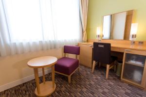 a hotel room with a desk and a mirror at Hotel Monterey Grasmere Osaka in Osaka