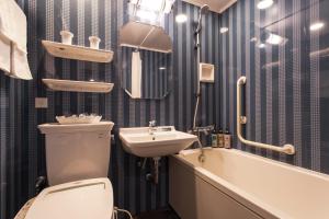a bathroom with a sink, toilet and bathtub at Hotel Monterey Grasmere Osaka in Osaka