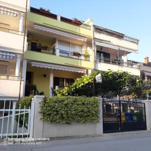 un edificio de apartamentos con una valla y arbustos delante de él en Apartments Elda, en Rovinj