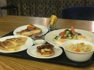 um tabuleiro com pratos de comida numa mesa em Corona Hotel em Vladivostok