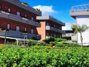 un edificio con balcones y plantas frente a él en Taormina Mare Piscina Fondachello, en Fondachello