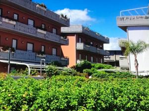 ein Gebäude mit Balkonen und Pflanzen davor in der Unterkunft Taormina Mare Piscina Fondachello in Fondachello