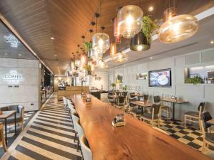 a restaurant with a large wooden table and chairs at Maitria Hotel Sukhumvit 18 Bangkok – A Chatrium Collection in Bangkok +88 photos