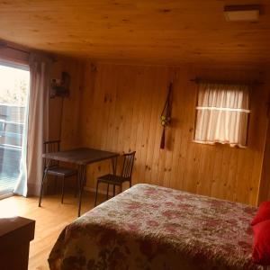 1 dormitorio con cama, mesa y ventana en Dulac Futrono, en Futrono