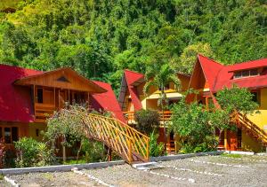 un groupe de maisons avec des toits rouges et des arbres dans l'établissement Hotel Rio Grande Lodge, à San Ramón