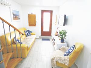 a living room with a yellow couch and two chairs at Le Pouffre, maison de pêcheur au quartier des artistes, clim, WiFi in Sète