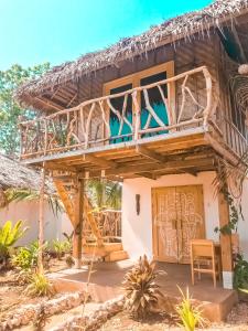 una casa con balcone e porta in legno di Mandala Tribe Treehouses a Siquijor