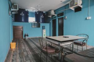 une salle à manger avec des murs bleus, une table et des chaises dans l'établissement RedDoorz near RSUD Koja, à Jakarta