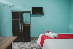 una camera da letto con un letto e una TV a parete di RedDoorz near RSUD Koja a Giacarta