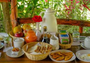 a table with baskets of breakfast foods and a jug at Hotel Rio Grande Lodge in San Ramón