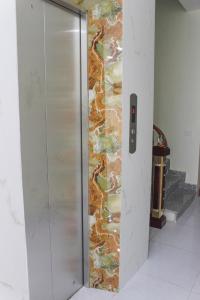 a elevator in a room with a mosaic wall at Duc Thang Guest House (Nhà Nghỉ Đức Thắng) in Diện Biên Phủ