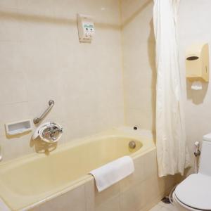 a bathroom with a bath tub and a toilet at Hotel Grasia in Semarang