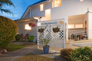 a house with a white gate with potted plants on it at Waimarie on Riverside Motel & Apartments in Nelson