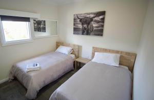 莫斯谷Argyle Hotel Southern Highlands的有两张床和一扇窗户的卧室