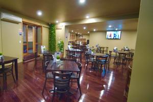 a restaurant with wooden tables and chairs and a tv at Argyle Hotel Southern Highlands in Moss Vale