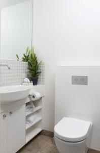 La salle de bains blanche est pourvue de toilettes et d'un lavabo. dans l'établissement Studio 7 - Saint George Accommodation, à Melbourne