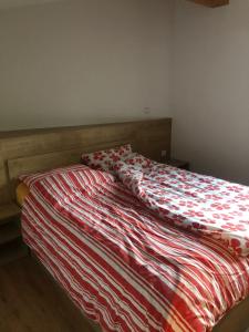 Una cama con un edredón rojo y blanco. en BC10 en Bovec