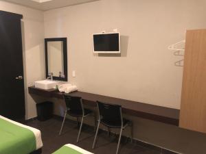 Habitación con escritorio con 2 sillas y espejo. en Hotel Raga Inn, en Tamasopo