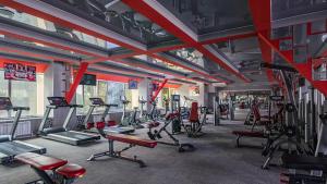 une salle de sport avec de nombreux tapis roulants et machines dans l'établissement Cronwell Park Nika, à Omsk