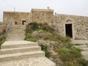 a stone building with stairs leading to a door at The Rock in Kapetanianá