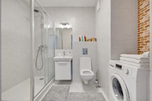 y baño blanco con aseo y ducha. en Apartment Kordiana, en Cracovia
