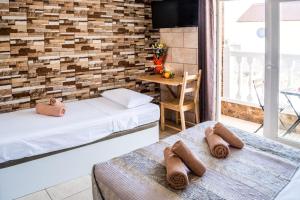 twee bedden in een kamer met een bakstenen muur bij Hostel Poseidon - HM in El Tablero