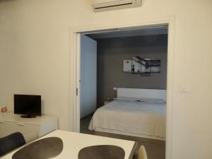 a bedroom with a bed and a table and a tv at Accademia 35 in Mantova