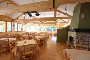 a restaurant with tables and chairs and a fireplace at Planinski dom Savica in Bohinj