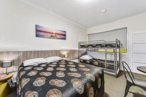 ein Schlafzimmer mit einem Bett und einem Etagenbett in der Unterkunft Rest Motels in Naracoorte