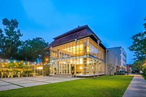 a large building with glass windows at night at Malaka Hotel Bandung in Bandung