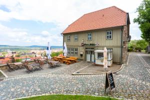 un bâtiment avec des tables et des chaises devant lui dans l'établissement Gasthof Obere Mühle, à Blankenburg