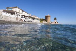 a body of water with a building and a lighthouse at Torremare in Marine du Miomo